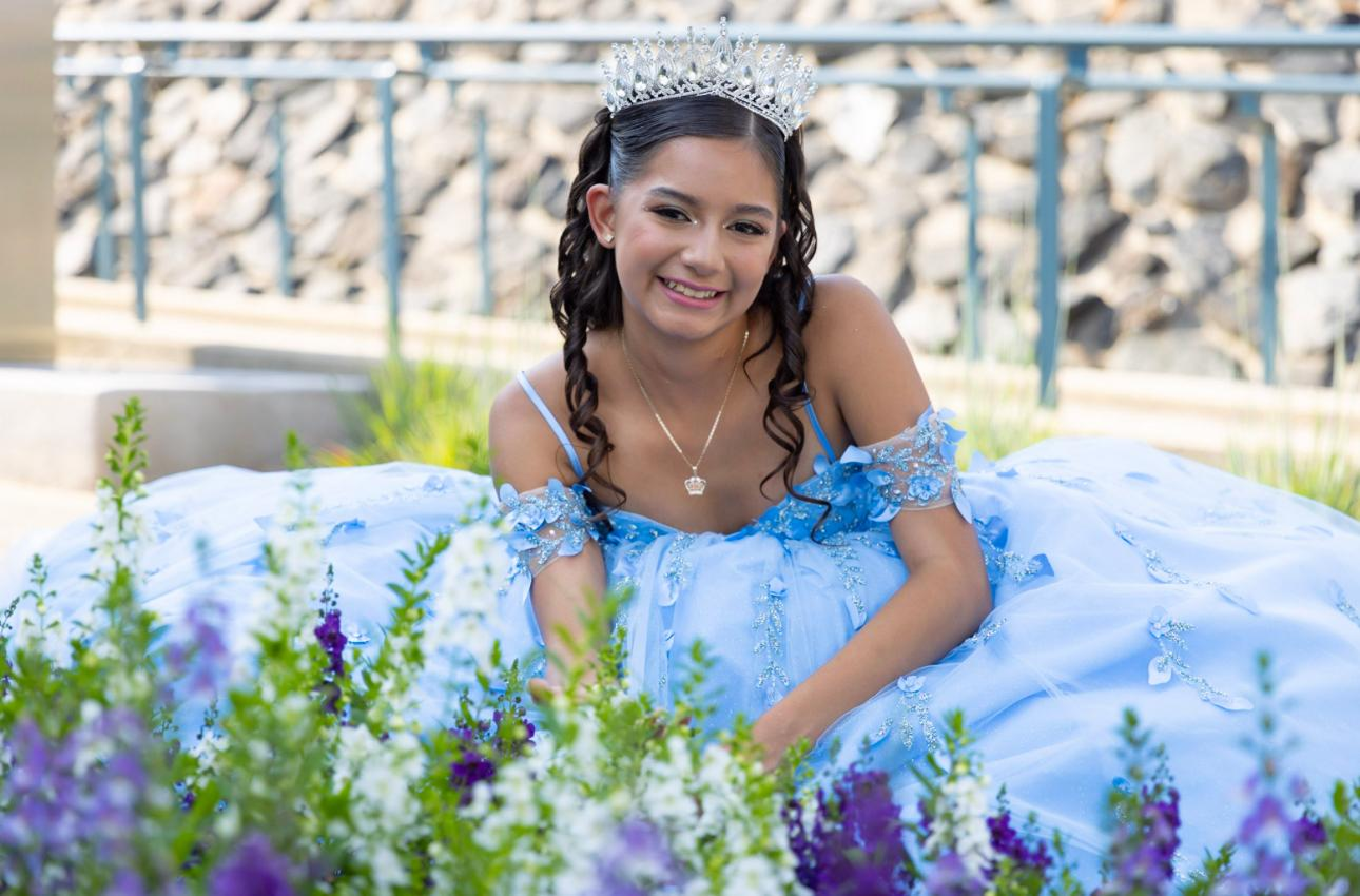 Quinceañera in blue gown among lavender florals